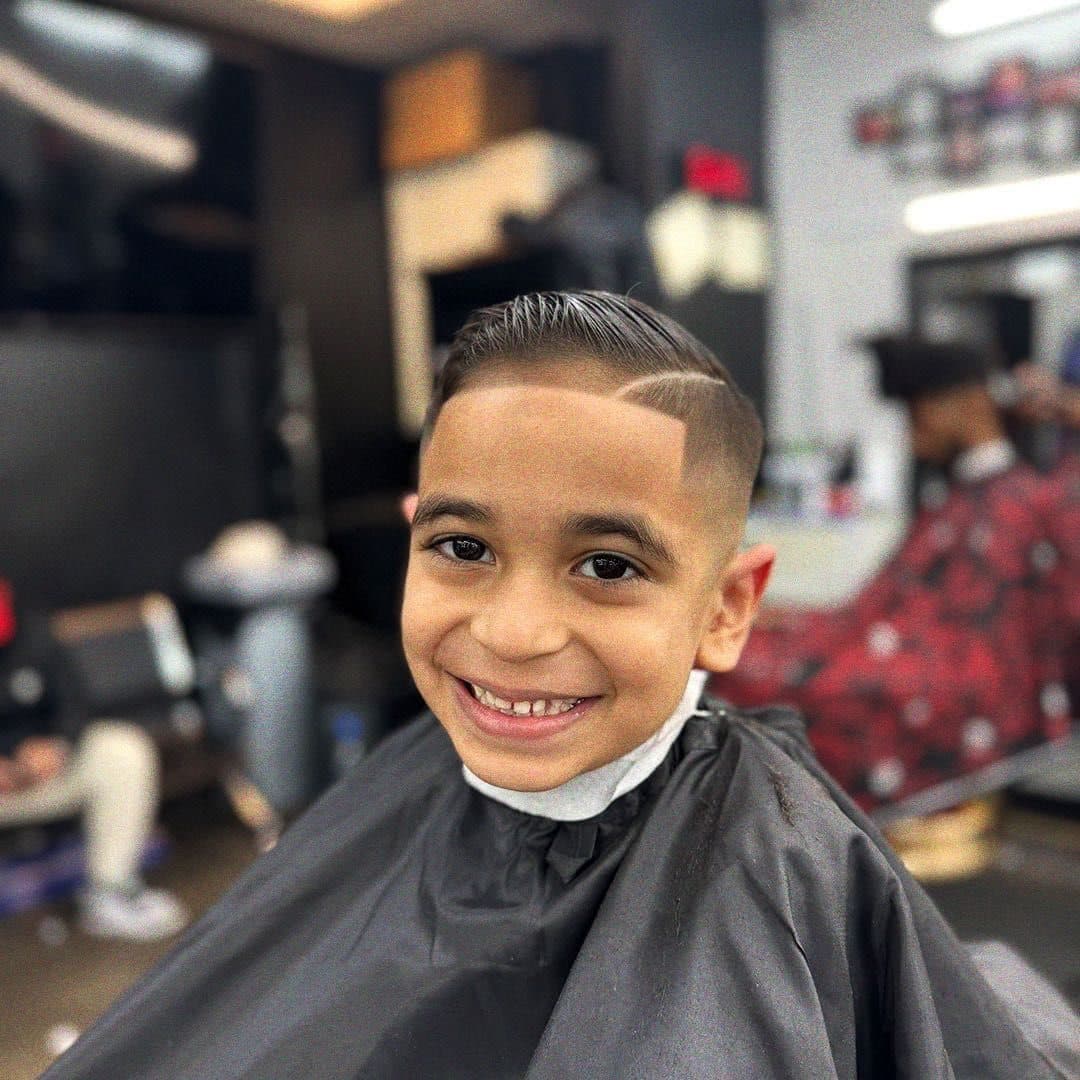 Un cliente joven sonriendo después de un fade con hard part